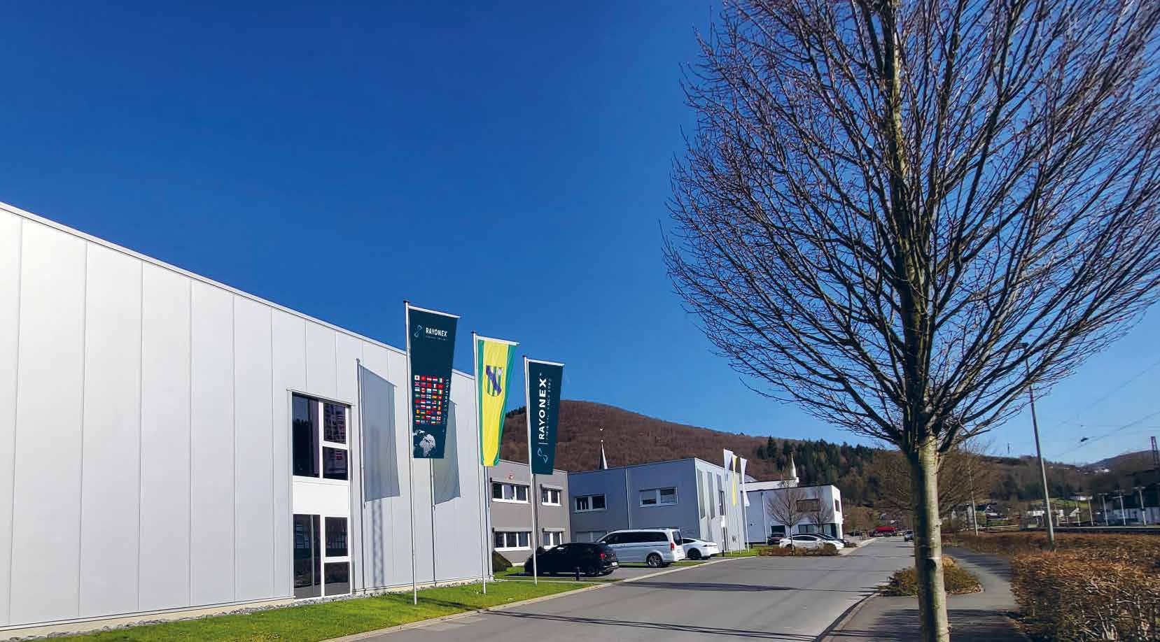 Die Rayonex-Manufaktur in Lennestadt mit Firmenfahnen